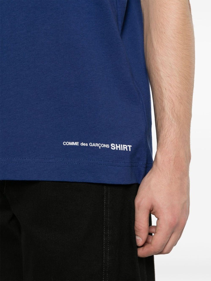 T-shirt blu logo sul fondo