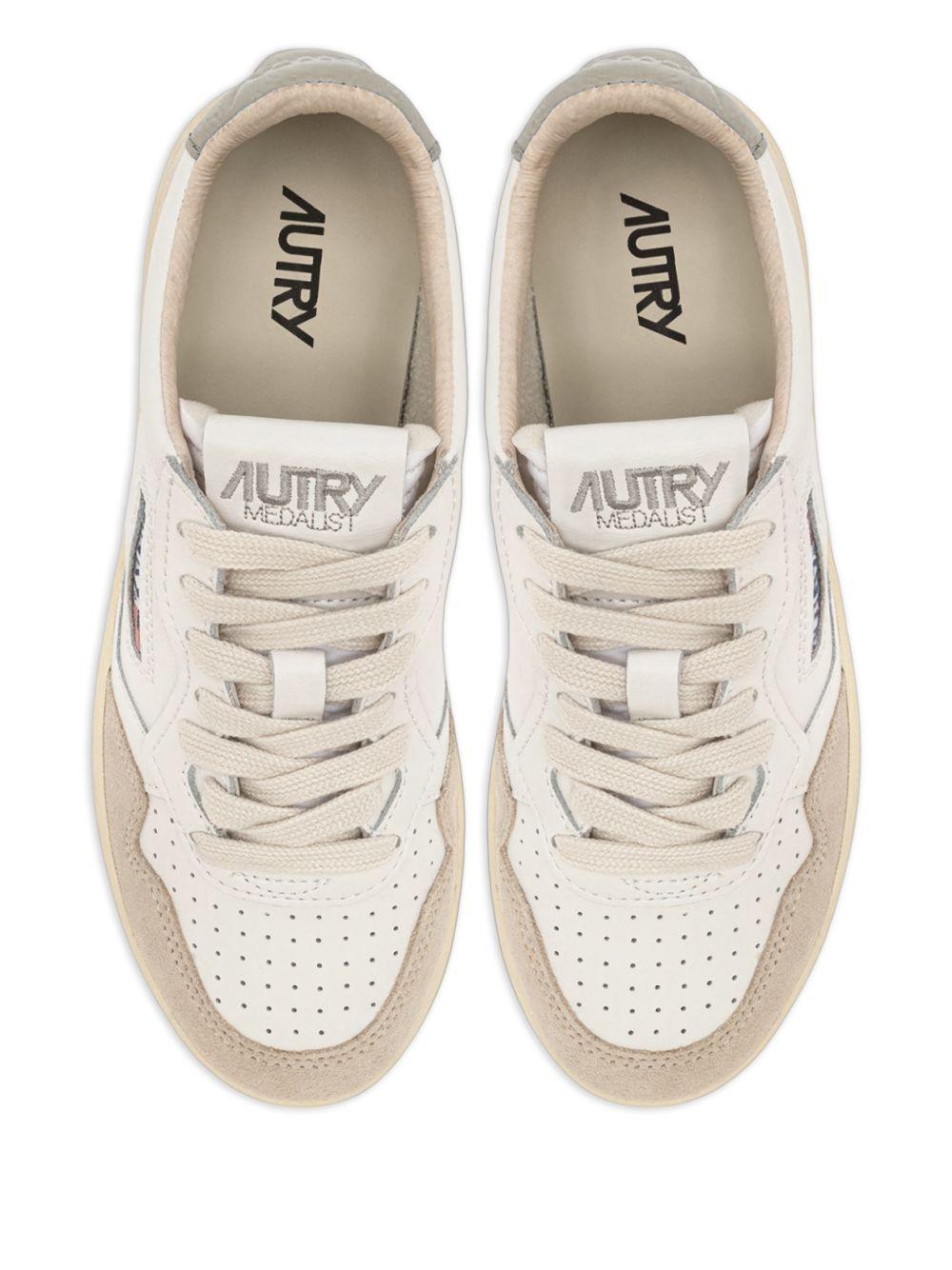 Sneakers bianche con applicazione logo 