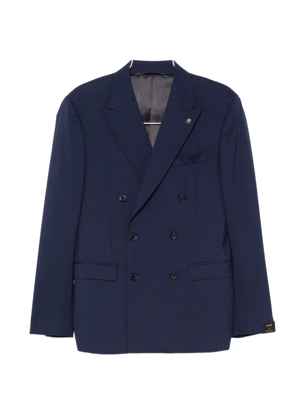 Abito blu doppiopetto con spilla sul revers 