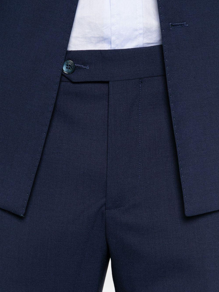 Abito blu doppiopetto con spilla sul revers 