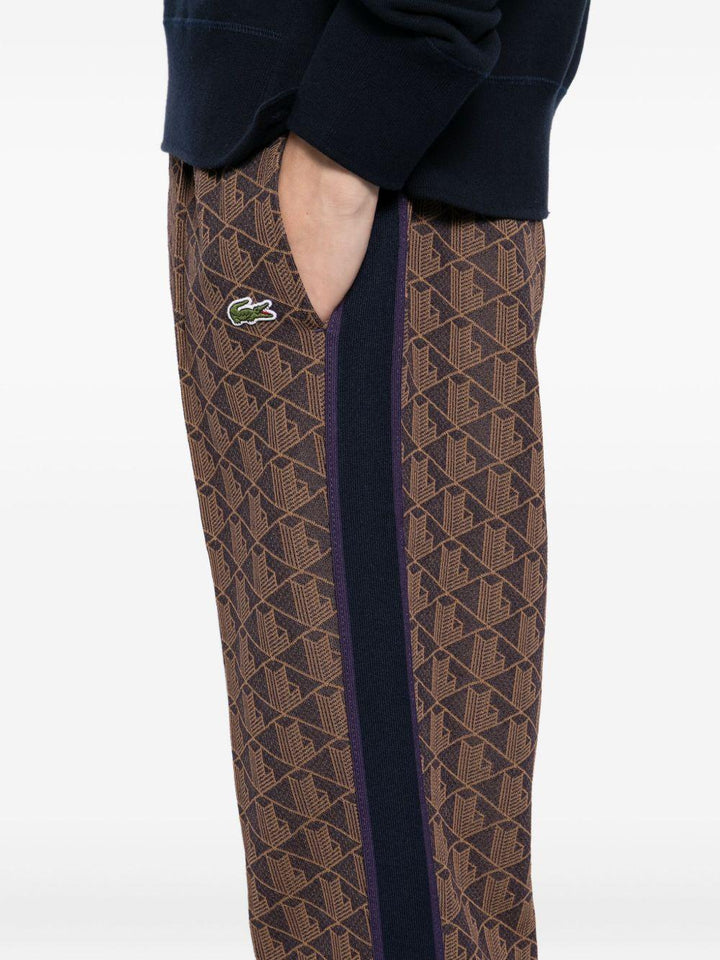 Pantaloni marrone scuro con applicazione logo 